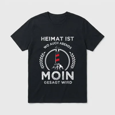 Heimat ist wo man auch T-Shirt – Leuchtturm im Lorbeerkranz mit Spruch „Moin gesagt wird“ – Klassisches T-Shirt in Schwarz